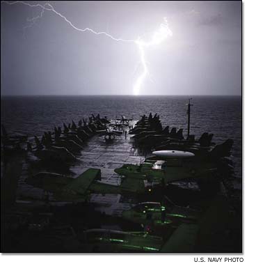 Lightning strikes light up the bow of the aircraft carrier USS Abraham Lincoln